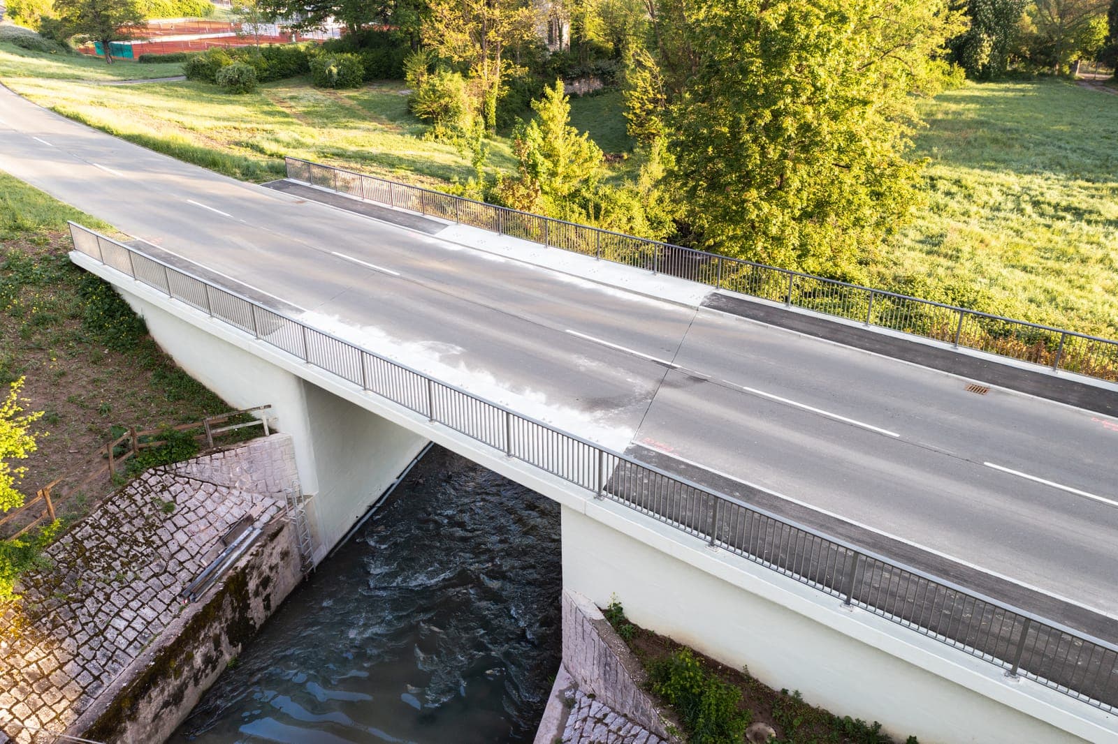 Fertig instandgesetzte Brücke mit neuer Fahrbahn und Geländer