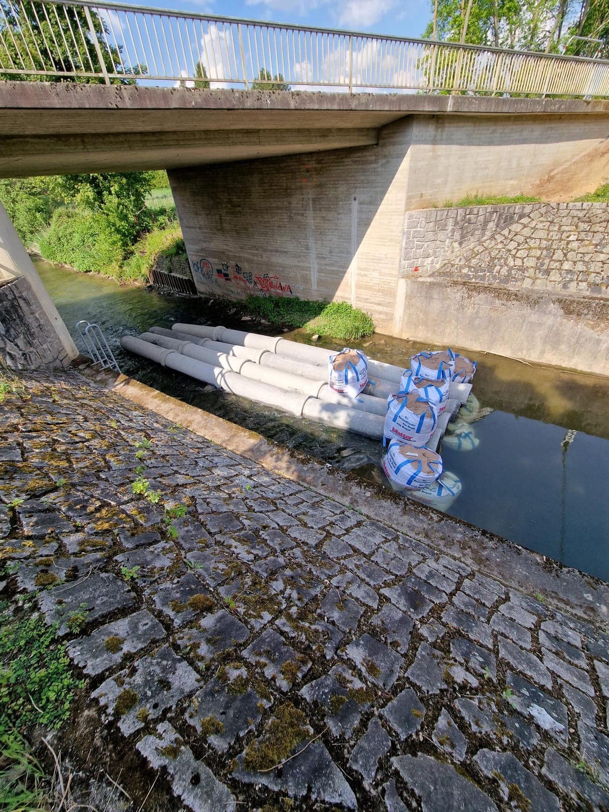 Brücke über die Brettach vor der Instandsetzung mit Gerüstrohren am Widerlager